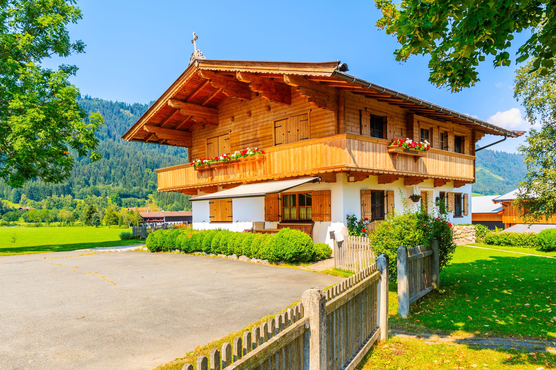 Traditionelles, mit Blumen geschmücktes Holzhaus im Dorf Reith bei Kitzbühel, Tirol, Österreich