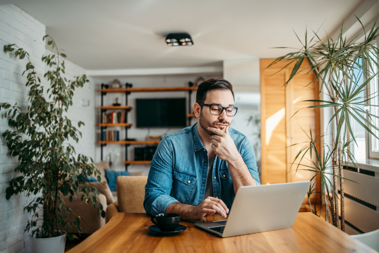 Nachdenklicher Mann am Laptop, der an einem SEO-Webinar teilnimmt, um sein Wissen gezielt in die Praxis umzusetzen.